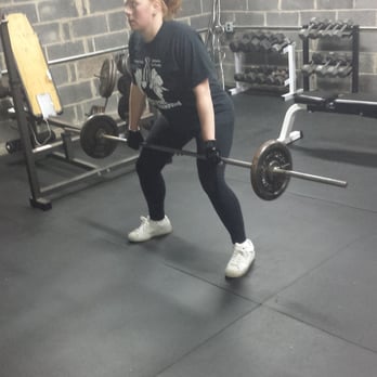 Toned at Home Personal Training - Meredith getting ready to set up for a barbell row in my garage gym. - Trainers Near Me Toned at Home Personal Training - Meredith getting ready to set up for a barbell row in my garage gym. - Trainers Near Me