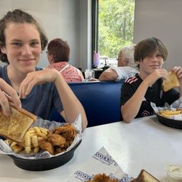 Kids reaching chicken.