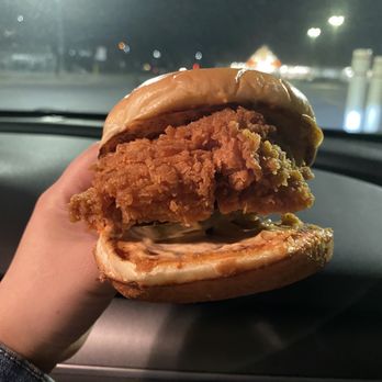 Popeyes Louisiana Kitchen - a hand holding a fried chicken sandwich - Chicken Shop Near Me - Kingston, Ontario Popeyes Louisiana Kitchen - a hand holding a fried chicken sandwich - Chicken Shop Near Me - Kingston, Ontario