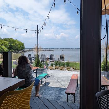 The Shipyard - a woman sitting at a table with a view of the water - Food Trucks Near Me - Pennsville Township, New Jersey The Shipyard - a woman sitting at a table with a view of the water - Food Trucks Near Me - Pennsville Township, New Jersey