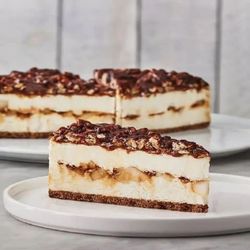 Apple Caramel Cheesecake: Creamy cheesecake encrusted with fresh apples, pecans and caramel on a Graham cookie base.