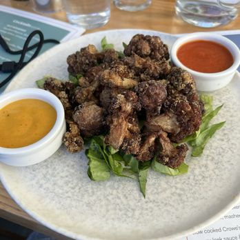 The Castle - Cauliflower Bravas is the name of this dish and it has tahini ketchup sauce, turmeric aioli and coriander too. - Mediterranean Near Me - Cork, Colorado The Castle - Cauliflower Bravas is the name of this dish and it has tahini ketchup sauce, turmeric aioli and coriander too. - Mediterranean Near Me - Cork, Colorado
