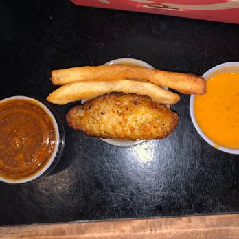 Nando's Peri-Peri - Tiny wing next to normal sized fries and normal sized sauce containers - South African Near Me - Towson, Maryland