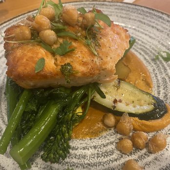 Olivia's Cafe - Salmon with squash, zucchini, and potatoes topped with a fire roasted chickpeas and a fresh squeezed lemon. - New American Near Me - Lake Buena Vista, Florida Olivia's Cafe - Salmon with squash, zucchini, and potatoes topped with a fire roasted chickpeas and a fresh squeezed lemon. - New American Near Me - Lake Buena Vista, Florida