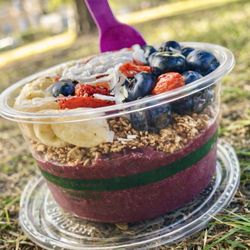 Açaí bowl loaded with blueberries, goji berries, bananas, strawberries, classic granola, and coconut flakes.