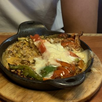 Casa Mexicana - a skillet of food on a wooden board - Mexican Near Me - Olive Branch, Mississippi