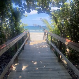 One of many entrances to Juno Beach. This entrance has a  concrete bench in the shade.