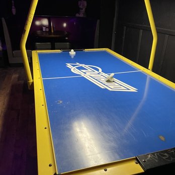 Dingo's Den - a blue and yellow air hockey table - Dive Bars Near Me - Clifton, New Jersey