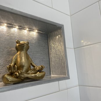 Muir Construction - a gold frog sitting on a shelf - General Contractors Near Me