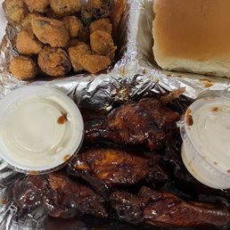 a tray of chicken wings, fries, and a burger a tray of chicken wings, fries, and a burger