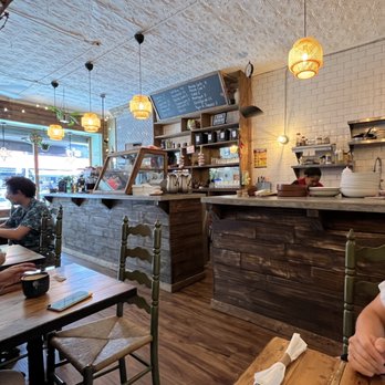 Cafe Miguel - a man sitting at a table in a restaurant - Coffee & Tea Near Me - Brooklyn, New York