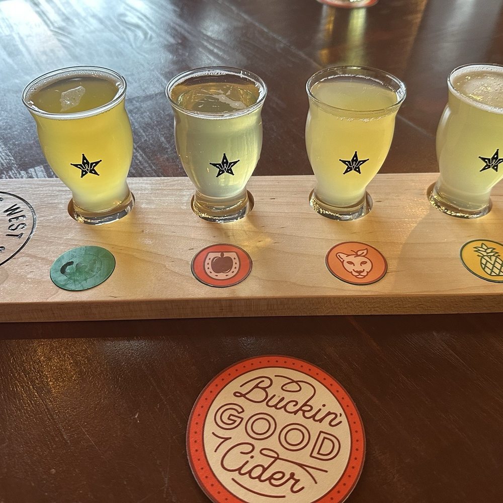 Vanishing West Ciders - Cider Flight: (left to right) Champagne Weather, Let's Mosey, Cougar Juice, and Campground Swinger - Cideries Near Me - Aurora, Colorado Vanishing West Ciders - Cider Flight: (left to right) Champagne Weather, Let's Mosey, Cougar Juice, and Campground Swinger - Cideries Near Me - Aurora, Colorado