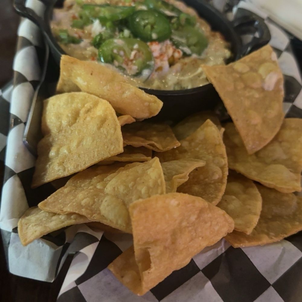 Remi’s Arcade & Bistro - Elote dip and chips. The jalapeños on top are fresh but not too spicy. Truly a delicious dish. - Sports Bars Near Me - Bartlesville, Oklahoma Remi’s Arcade & Bistro - Elote dip and chips. The jalapeños on top are fresh but not too spicy. Truly a delicious dish. - Sports Bars Near Me - Bartlesville, Oklahoma