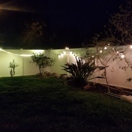 a white fence with string lights a white fence with string lights