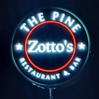 The Pine - a neon sign for zota's restaurant and bar - The image shows a circular neon sign with the text 'Zotto's' in the center. Surrounding it are the words 'The Pine' at the top and 'Restaurant & Bar' at the bottom, all illuminated with bright neon lights. The sign is set against a dark background, emphasizing the glowing colors and text, indicating it is for a restaurant and bar named Zotto's, located at The Pine. - Pizza Near Me - Troy, New York
