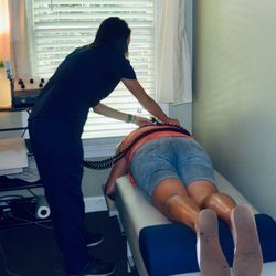 Dominion Family Chiropractic - A Chiropractic Assistant applying therapy to a patient.