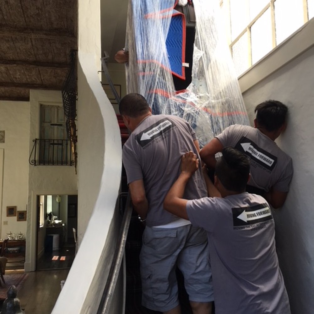 Moving Forward - heavy wood desk ascending narrow staircase with the help of four people - Movers Near Me Moving Forward - heavy wood desk ascending narrow staircase with the help of four people - Movers Near Me