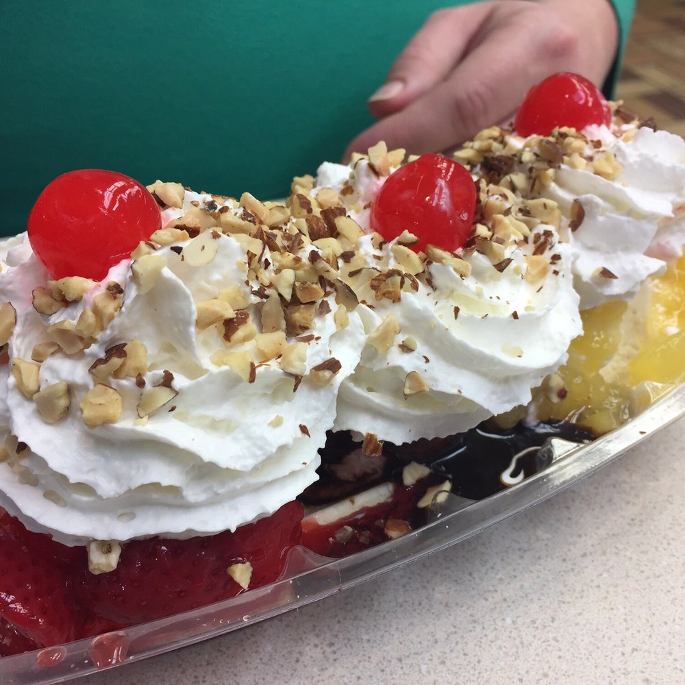 a banana split with whipped cream, cherries, and nuts a banana split with whipped cream, cherries, and nuts