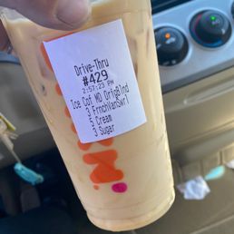  a hand holding a cup of iced coffee