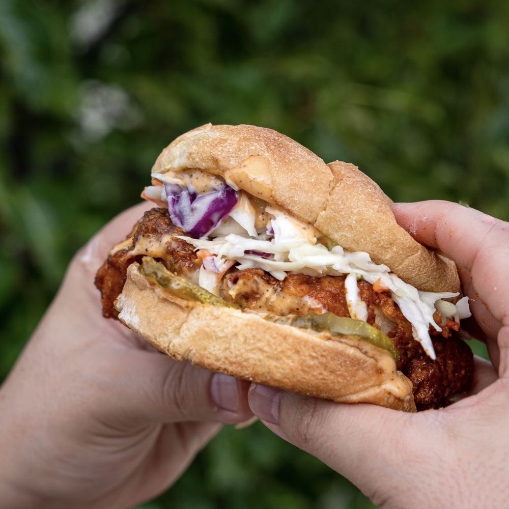 Holy Cluck - a person holding a sandwich in their hand - Sandwiches Near Me - Dearborn, Michigan