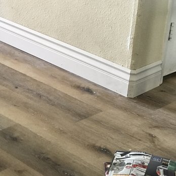My Floors Direct - a cat sitting on the floor next to a pile of magazines - Flooring Near Me - Murrieta, California