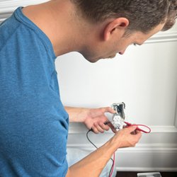 Daniel Electric - Kristopher Daniel, master electrician, inspecting an outlet