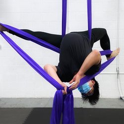 Ringstar Studio - A student performs inverted splits on the aerial silks