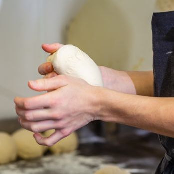 Milanos Pizza - a person kneading dough - Italian Near Me - Heath, Texas Milanos Pizza - a person kneading dough - Italian Near Me - Heath, Texas