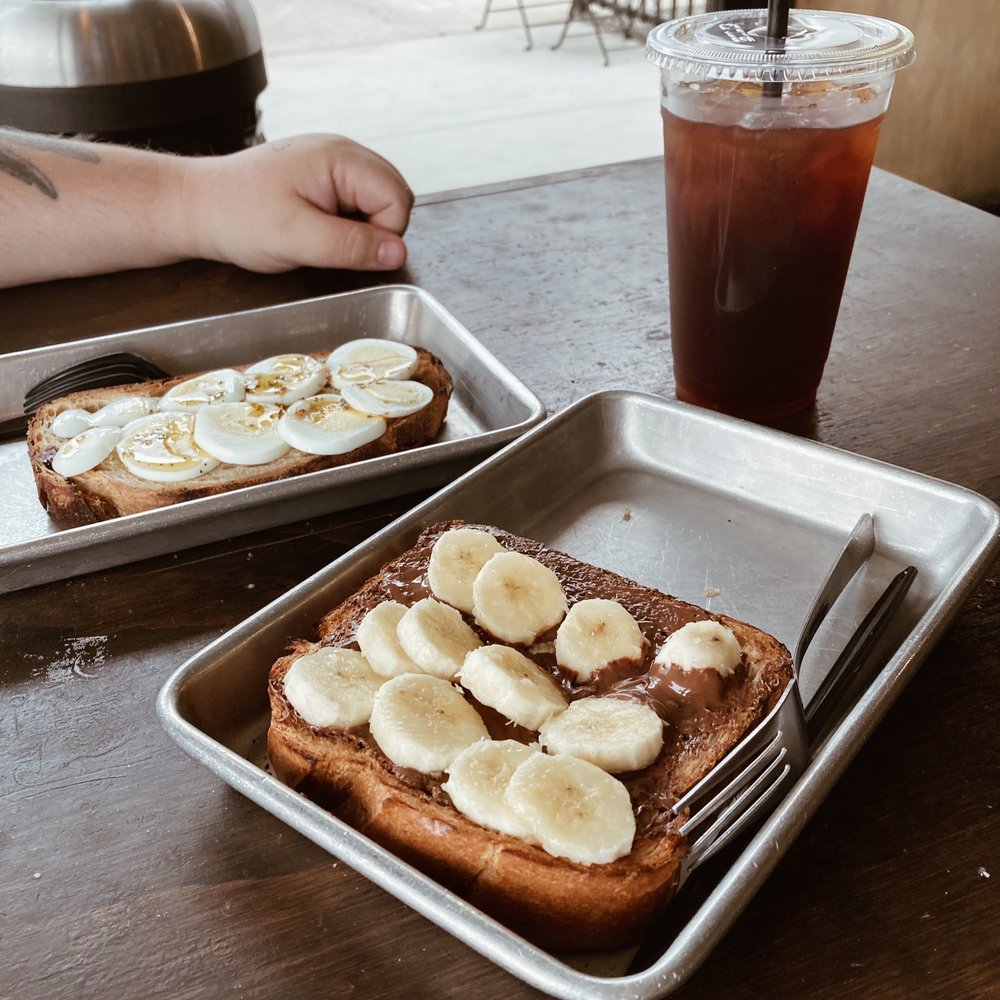 Brot Coffee - Brioche toast with Nutella and bananas, roasted garlic and rosemary toast with olive oil and boiled egg, and a large cold brew, black. - Coffee & Tea Near Me - Orange, California Brot Coffee - Brioche toast with Nutella and bananas, roasted garlic and rosemary toast with olive oil and boiled egg, and a large cold brew, black. - Coffee & Tea Near Me - Orange, California