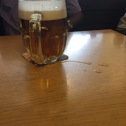 The beer spills on the table after being dumpef