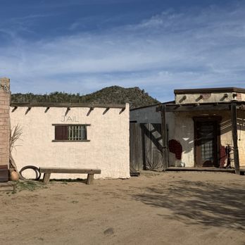 Western Destinations - A western-themed building with a small jail cell marked 'JAIL' and a mountain in the background, set in a desert landscape. - Venues & Event Spaces Near Me - Phoenix, Arizona