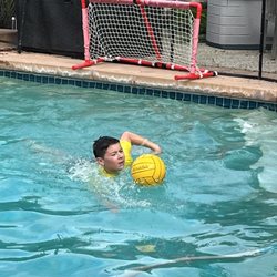 A Splashing Success Swim School - Learning to dribble the ball while swimming.
