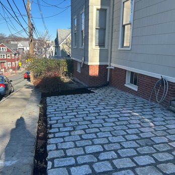 EHM Construction - New cobble stone driveway on sloping retaining wall with room for succulents to grow between the cable stone and the retaining wall. - Roofing Near Me - Chelsea, Massachusetts