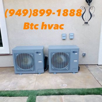 BTC HVAC SYSTEM - Two 4PRO AC condenser units with protective grilles on a concrete pad, connected by black refrigerant lines, cleanly installed - Heating & Air Conditioning/HVAC Near Me BTC HVAC SYSTEM - Two 4PRO AC condenser units with protective grilles on a concrete pad, connected by black refrigerant lines, cleanly installed - Heating & Air Conditioning/HVAC Near Me