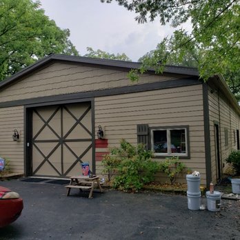 Millan Painting - a garage with a red car parked in front of it - Painters Near Me
