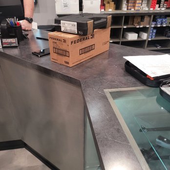 Ottomanelli's Sporting Arms - I'm picking up my first firearm. - The image shows a checkout counter at a firearm store with a cardboard box labeled 'Federal' and a black case on top, along with a smartphone and paperwork. - Guns & Ammo Near Me - Paramus, New Jersey