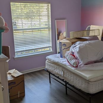 Roberts Custom Flooring - a bedroom with a bed and a dresser - Flooring Near Me