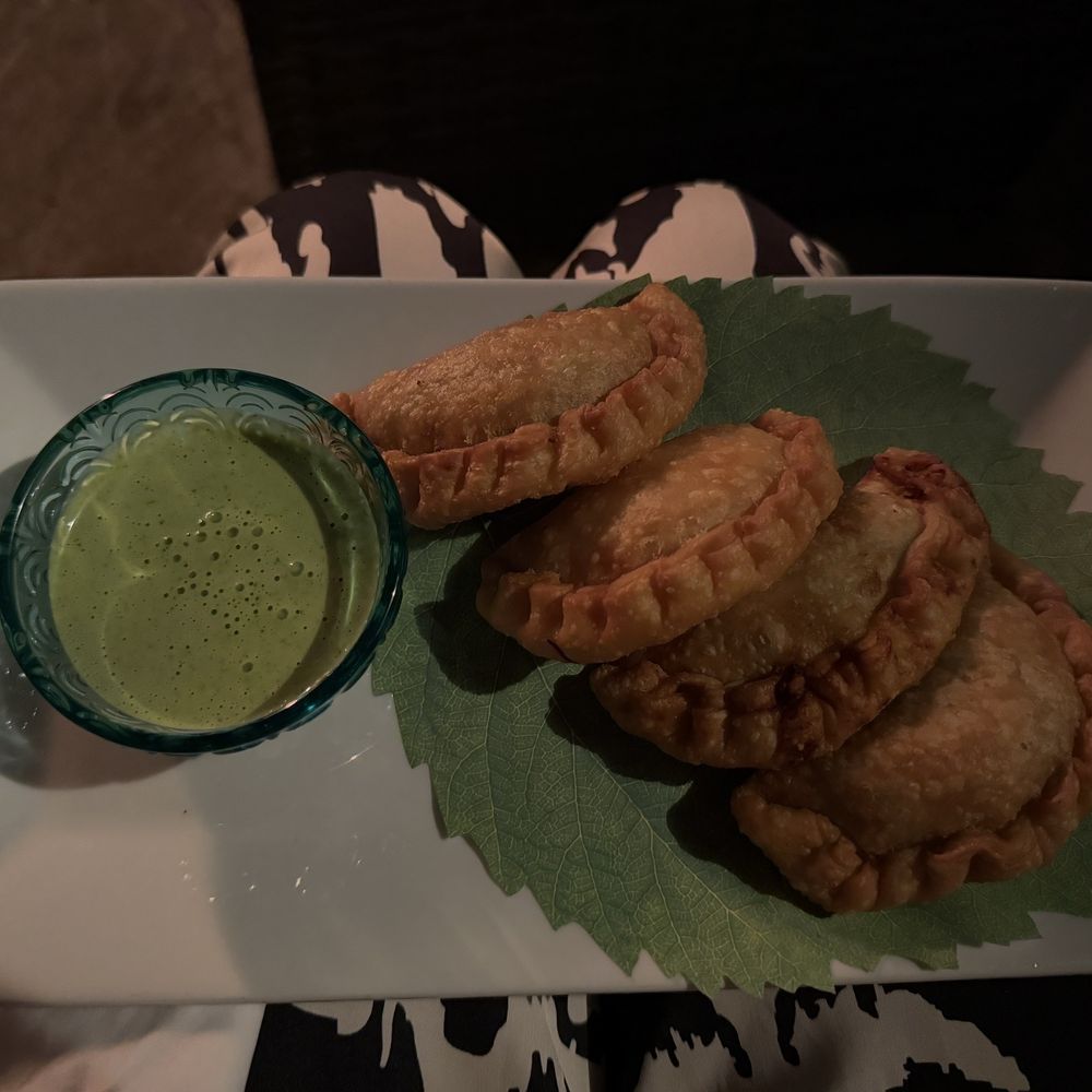 An assortment of empanadas with a creamy cilantro sauce that is so delicious. Everything is made in house!