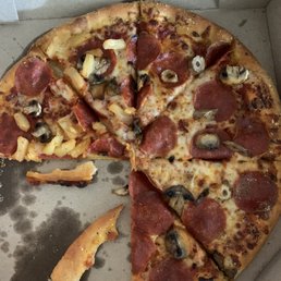 Pizza missing banana peppers on one side. Pizza missing banana peppers on one side.