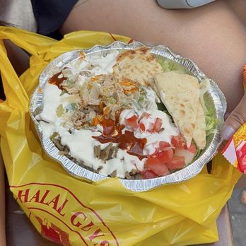 The Halal Guys - A full platter packed with meat, vegetables, rice and topped with sauce. - Middle Eastern Near Me - New York, New York