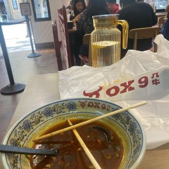 Ox9 Lanzhou Handpulled Noodles - Leftover mala broth. Soiled bib on table. - Noodles Near Me - Berkeley, California