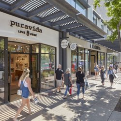 Shoppers walk past Pura Vida and Athleta along an outdoor walkway at SanTan Village.