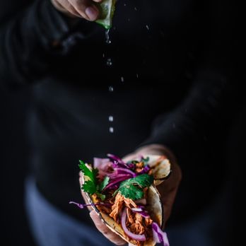 Edge Gourmet Street Kitchen - a hand sprinkling lime over a taco - Food Trucks Near Me - Frederick, Colorado