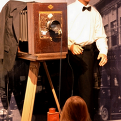 Bartlesville Area History Museum - photographer Frank Griggs and young girl looking on she wanted to know why his camera is so large.staff explained to her satisfaction.