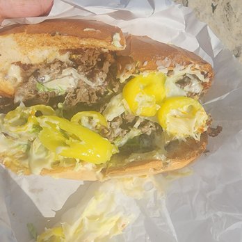 Louie's Pizza - a hand holding a sandwich - Pizza Near Me - Rehoboth Beach, Delaware Louie's Pizza - a hand holding a sandwich - Pizza Near Me - Rehoboth Beach, Delaware