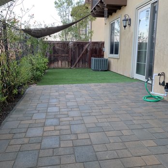 Magic Turf - a patio with a green hose - Lawn Services Near Me Magic Turf - a patio with a green hose - Lawn Services Near Me