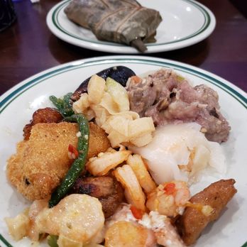 King Buffet - Buffet hodgepodge - A plate of assorted Asian cuisine featuring shrimp, green beans, fried items, and rice, with a second plate in the background containing a wrapped food item. The setting appears to be a buffet or restaurant table with additional dishes and utensils visible. - Buffets Near Me - Plano, Texas