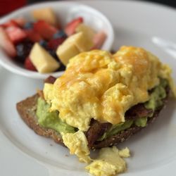 Hoggs Meat Market - B.A.E Avocado Toast with a side of fresh fruit.