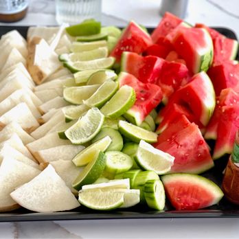 Kala Truck - a platter of sliced watermelon, limes, and cucumbers - Mexican Near Me