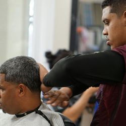 Michaelangelo's Barbershop and Nails  - Owner michaelangelo preforming men's haircut on a patron.